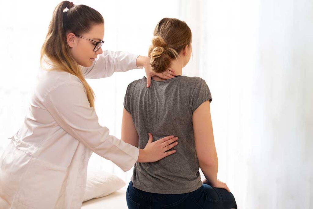 A chiropractor gently adjusts the neck of an adult patient in a calm clinical setting.